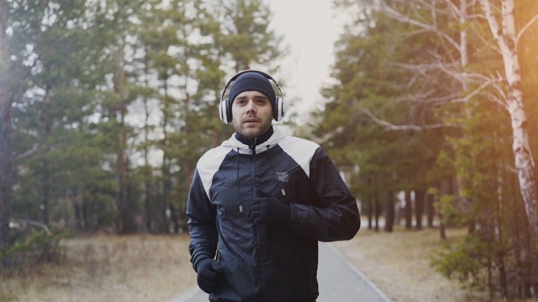 Löpare med hörlurar joggar lugnt på en skogsstig